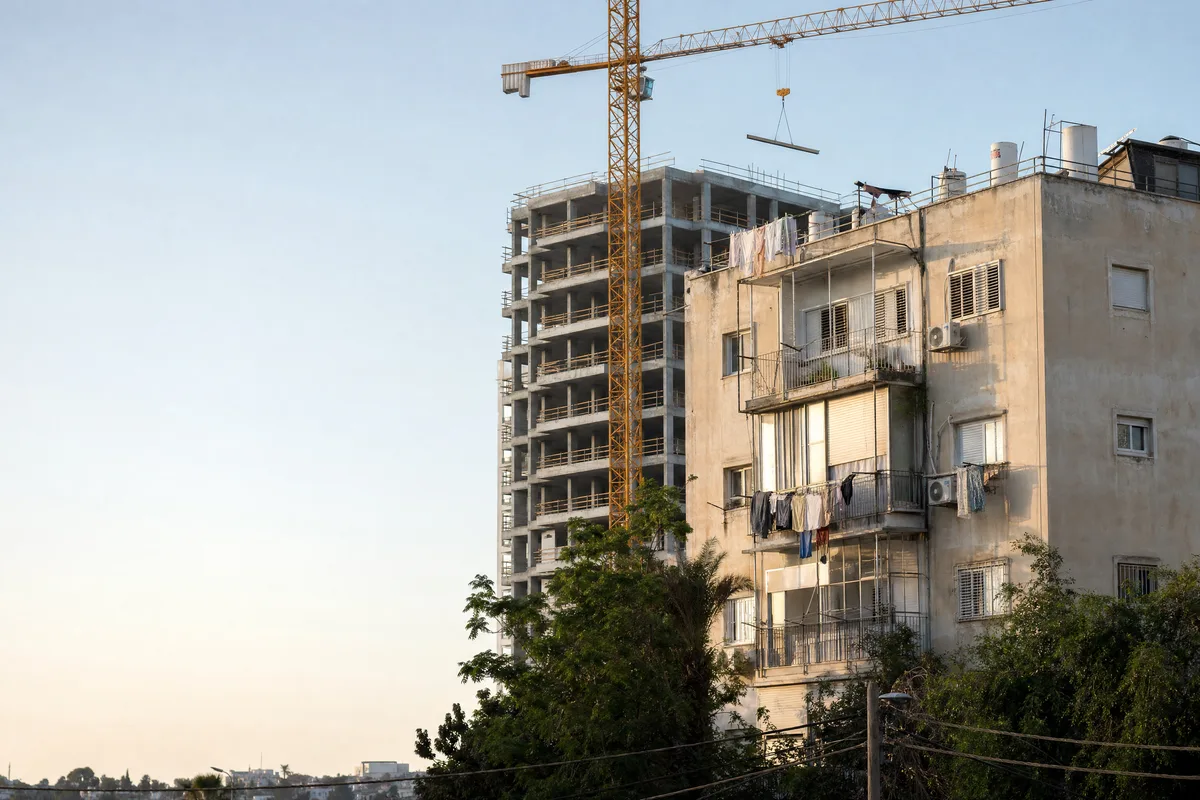 עורך דין פינוי בינוי, מתחם מגורים ותיק ולידו שלד בטון של בניין חדש עם מנוף בבני ברק